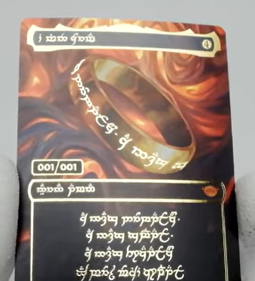 a hand holds the serialized one ring card which appears to be bent