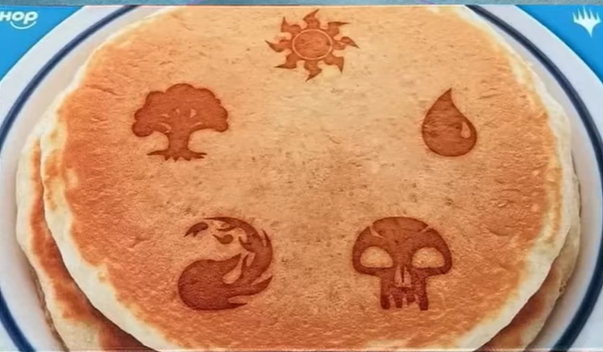 an mtg playmat that looks like a stack of pancakes with the mana symbols on them